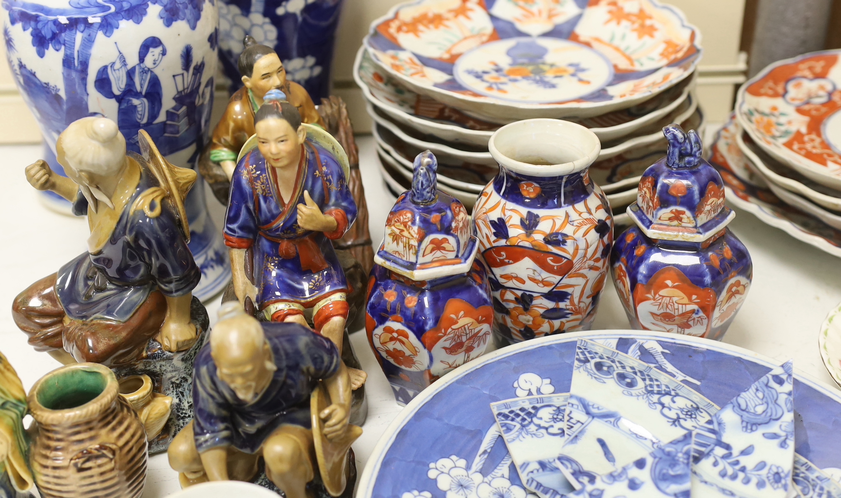 A collection of Chinese and Japanese pottery and porcelain including three vases, five figures, plates and bowls, vases 30cm